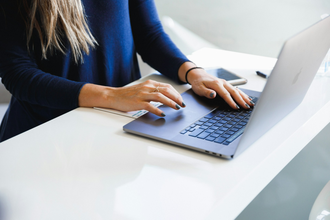 woman in blue long sleeves typing on laptop