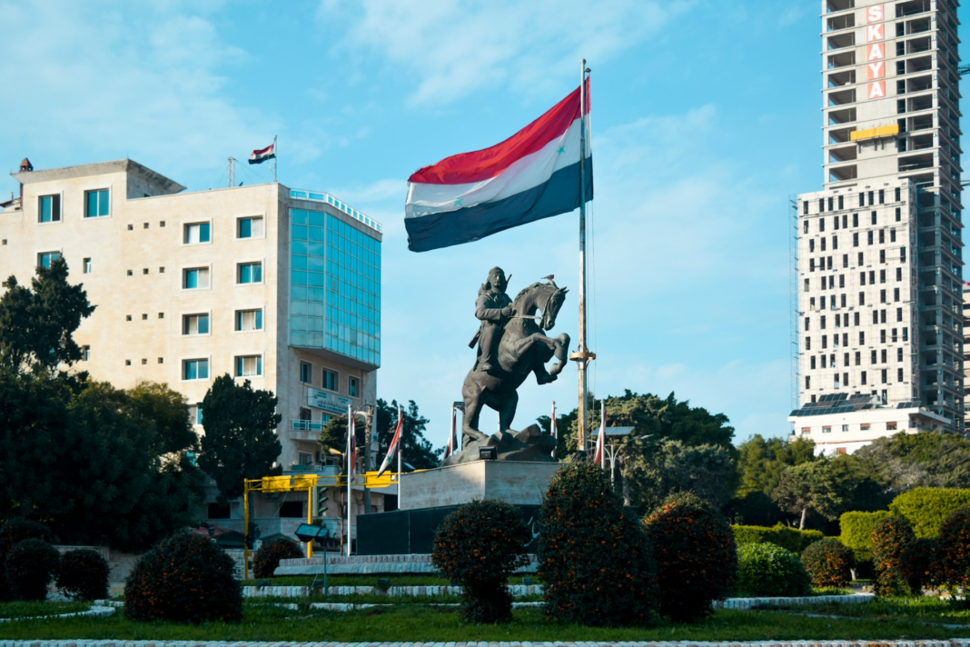 statue of a man riding a horse in front of the netherlands flag
