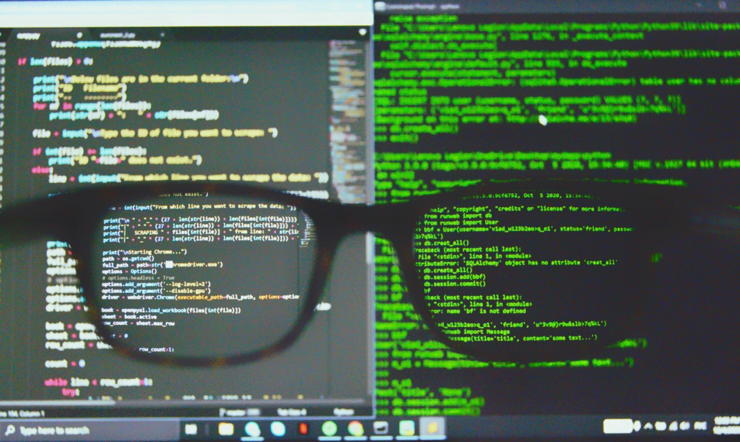 glasses in front of coding text on computer screen