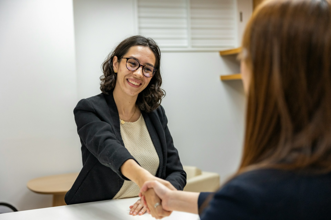 woman shaking another woman's hand